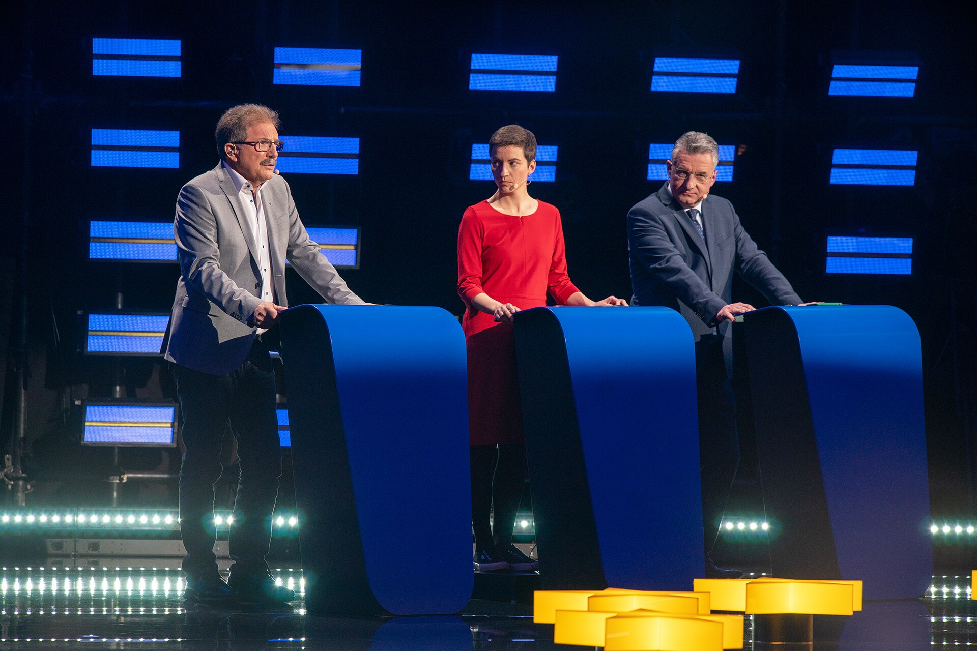 Flera kandidater står vid podier under en tv-debatt.