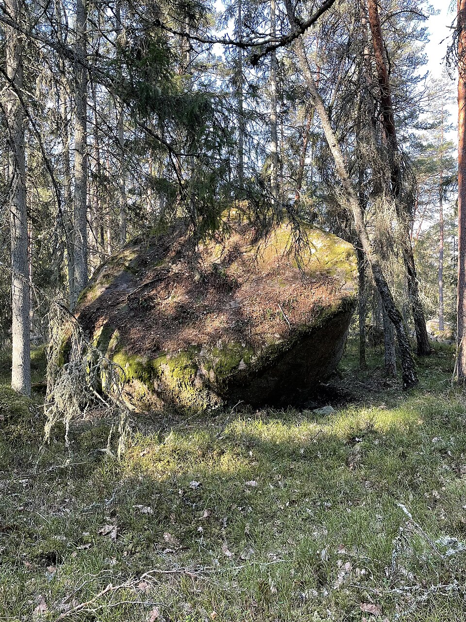 Ett stort flyttblock i ett svenskt skogslandskap.