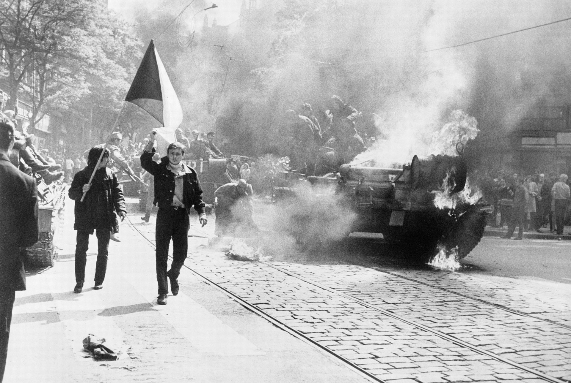 Tjeckoslovaker med flagga vid brinnande stridsvagn i Prag 1968.