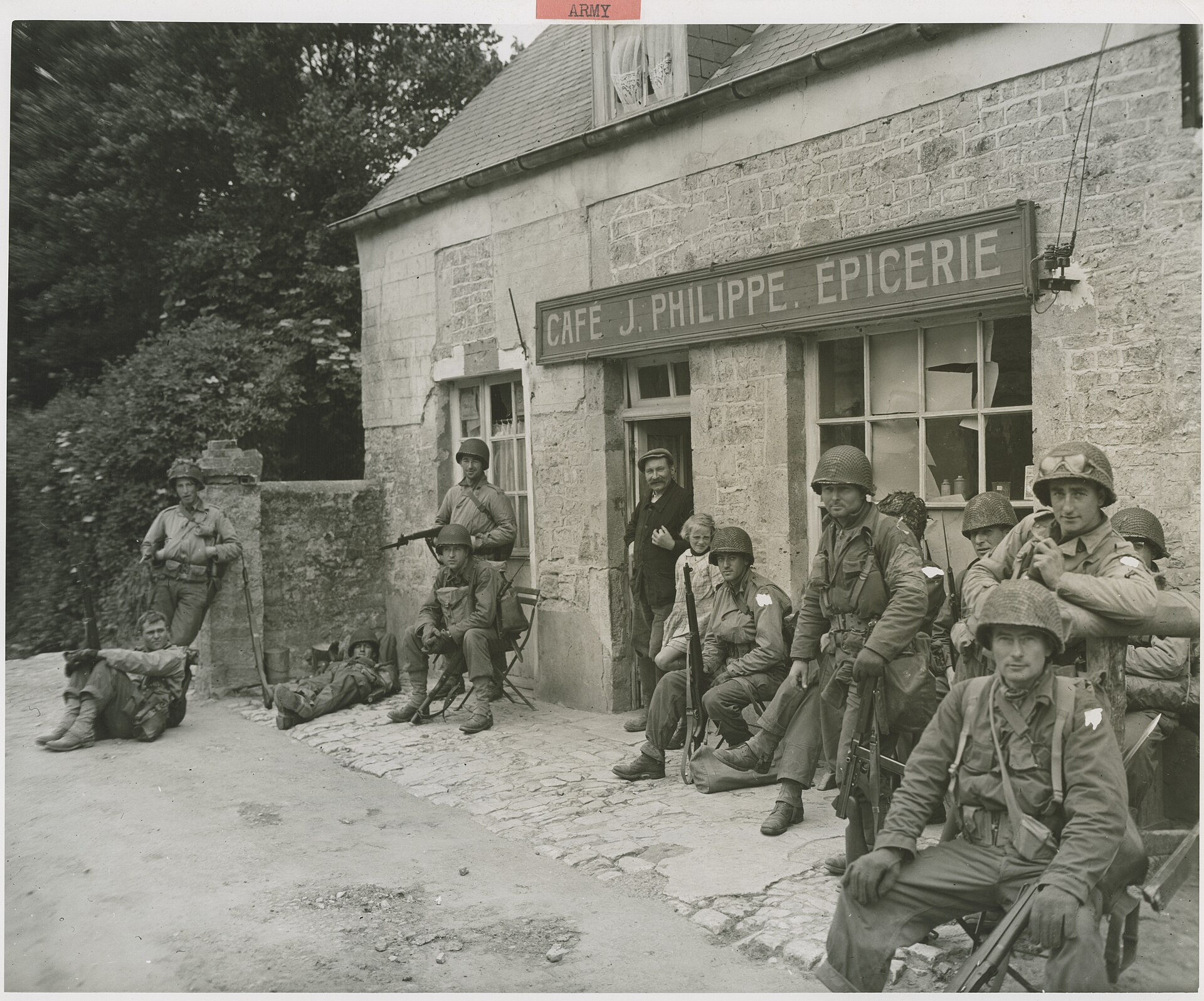 Amerikanska soldater vilar utanför ett franskt kafé 1944