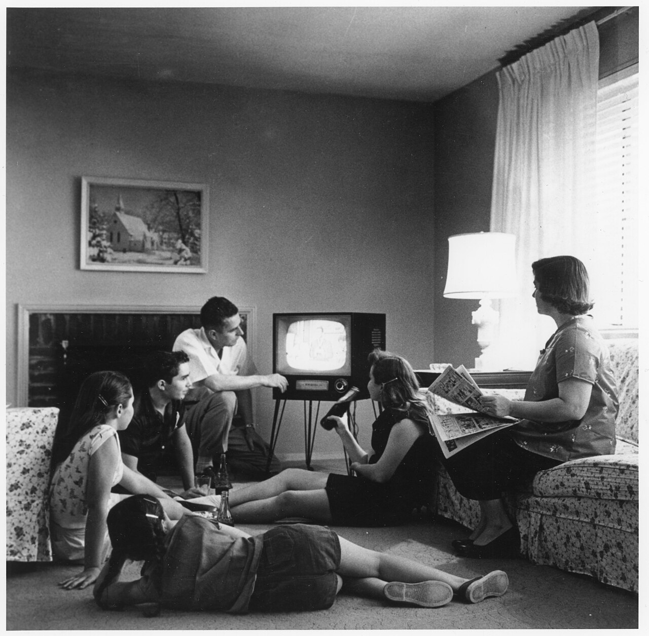 Familj tittar på TV i vardagsrum 1958.