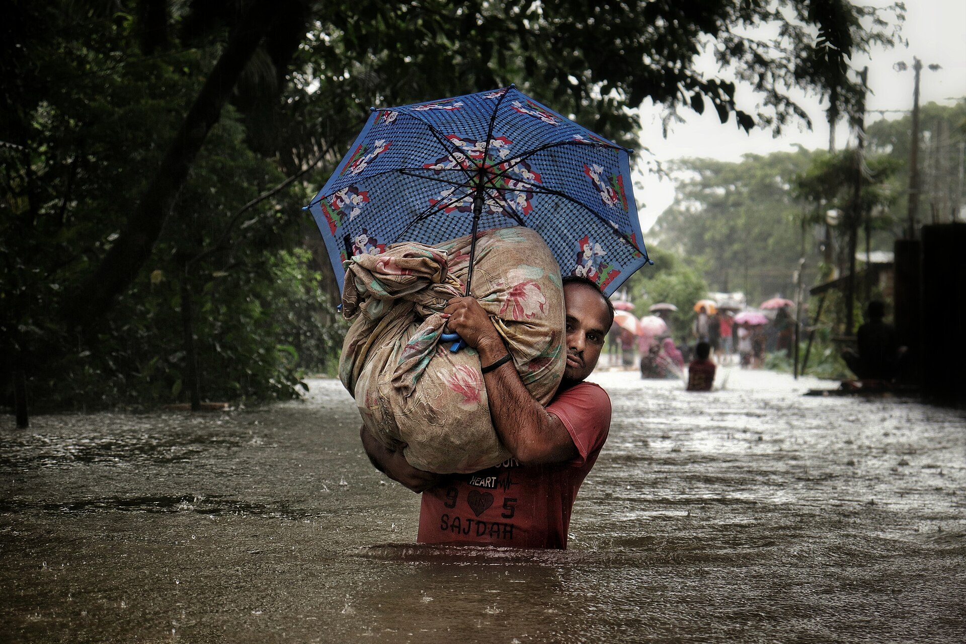Man flyr från översvämning i Sylhet, Bangladesh