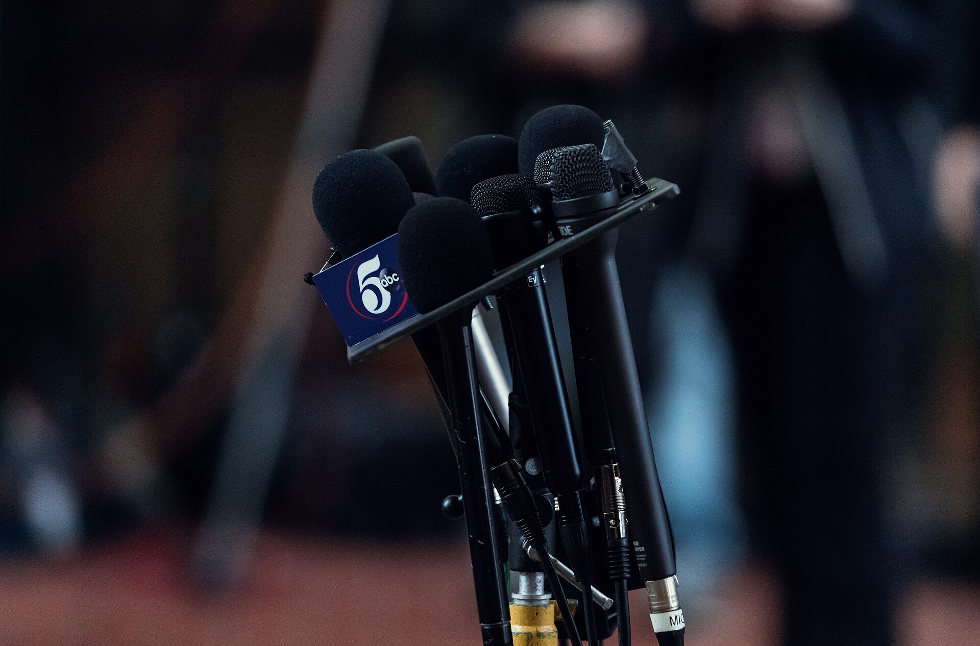 Mikrofoner från olika nyhetsmedier vid en presskonferens.