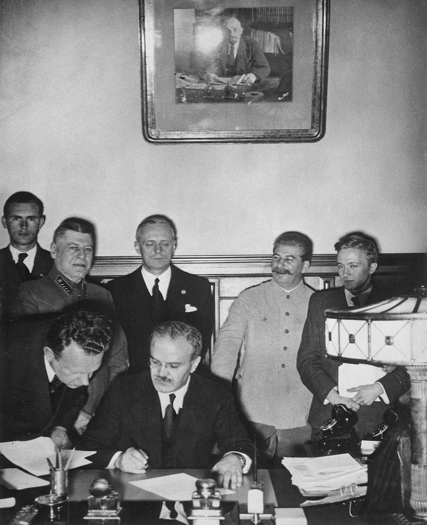 Molotov skriver under pakten medan Ribbentrop och Stalin står bakom