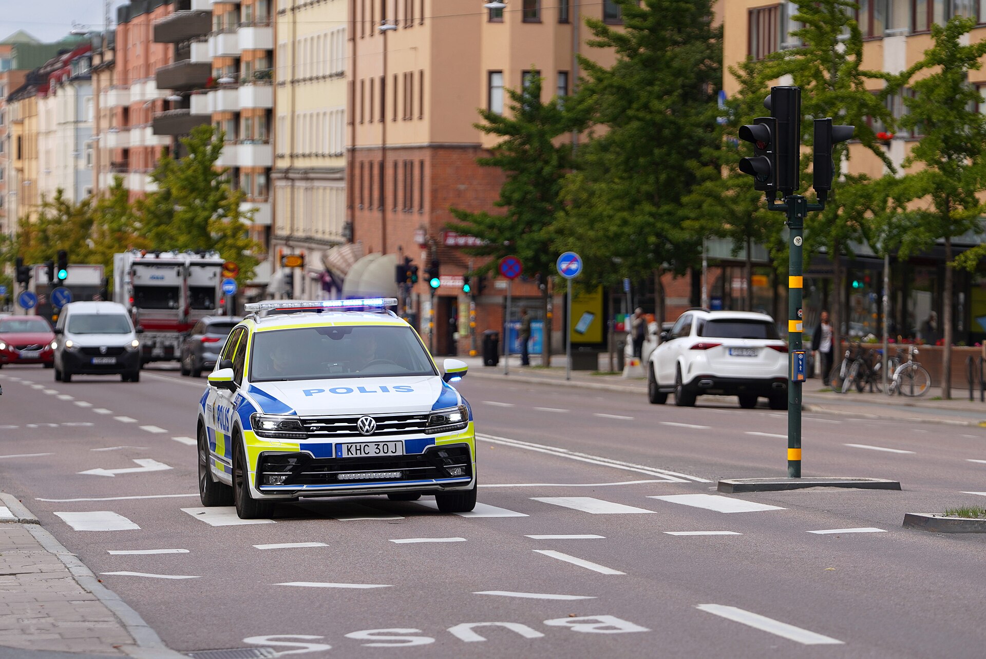 Svensk polisbil med blåljus påslagna.
