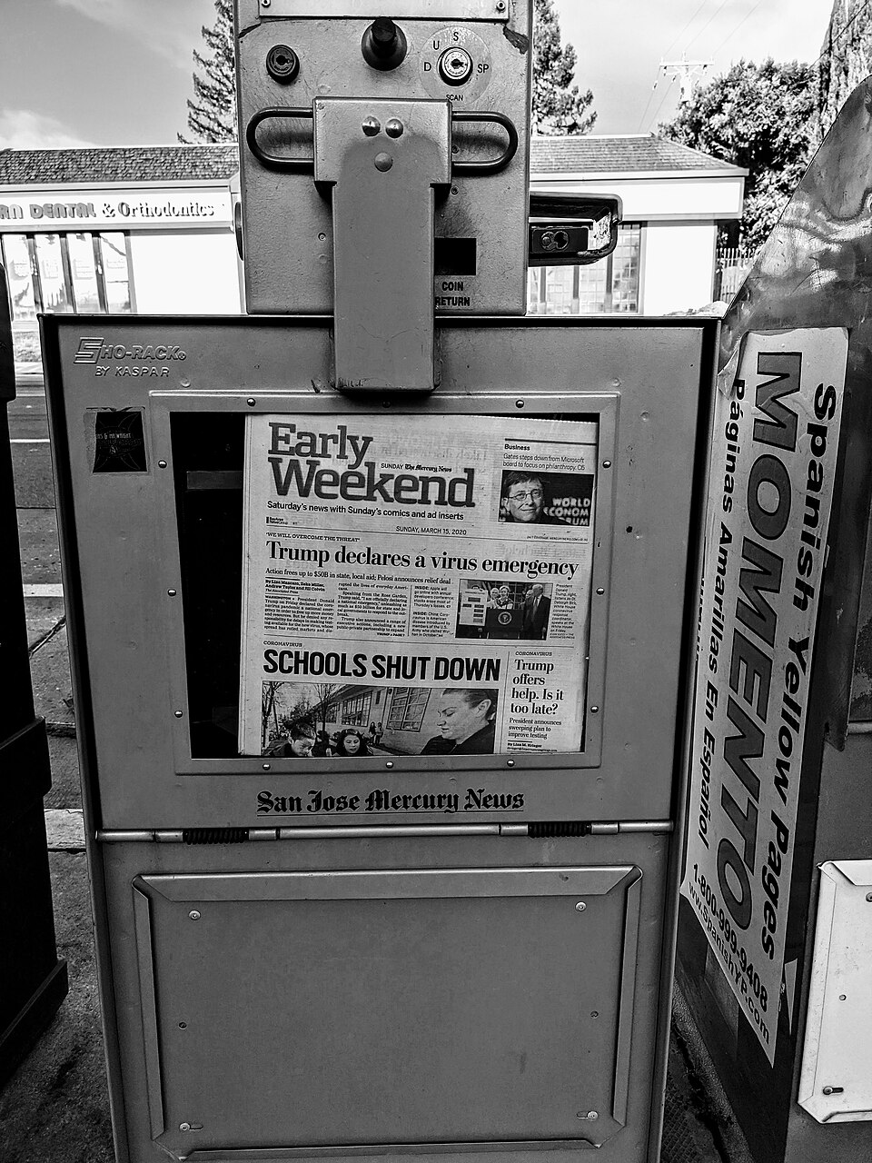 Flera tidningar i en automat med stora rubriker på framsidorna.